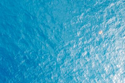 Mid-altitude coastal drone still over blue water (example 3 of 4).